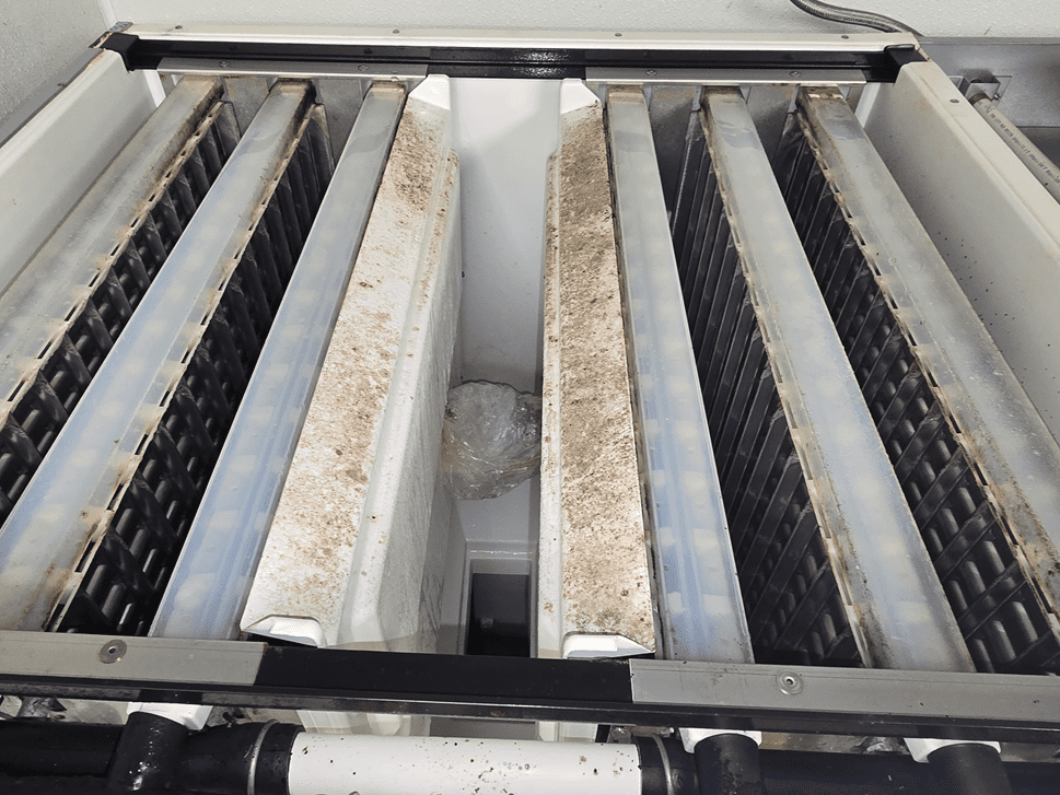 Heavy mineral scale and debris buildup inside an ice machine evaporator