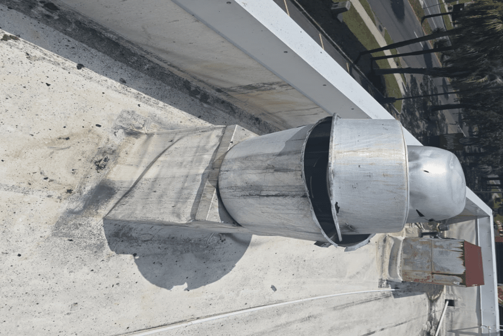 Old exhaust fan removed — full condition visible after removal from roof curb