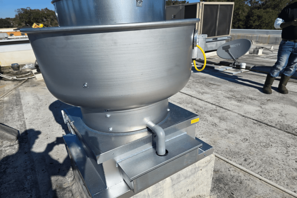 Side view: new Captive Aire unit set on prepared roof curb, grease drain line properly routed