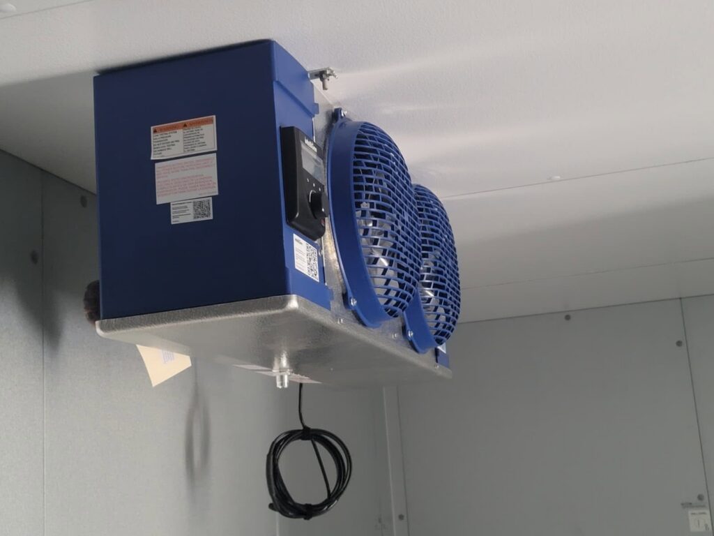 Walk-in cooler evaporator fans working overtime during peak summer heat.