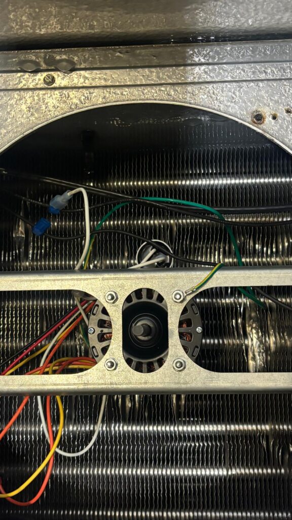 New evaporator fan motor installed and securely wired inside the coil housing.
