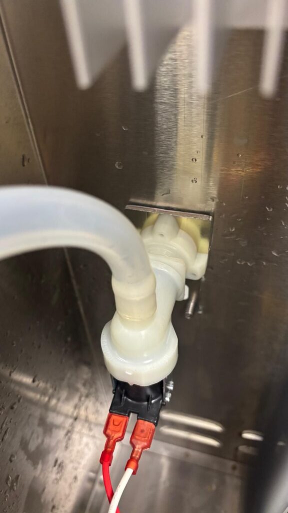 New water inlet valve installed, reconnected, and secured back in its mounting bracket.
